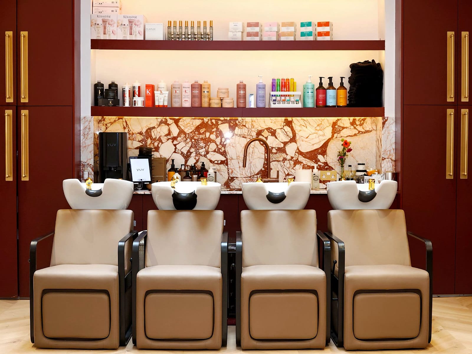 Four backwash chairs against the marble wall at Hakim Elhocine Hair Couture, Mayfair
