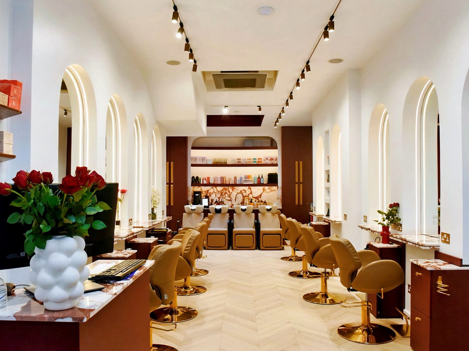 The styling floor at Hakim Elhocine Hair Couture seen from reception, roses on the desk
