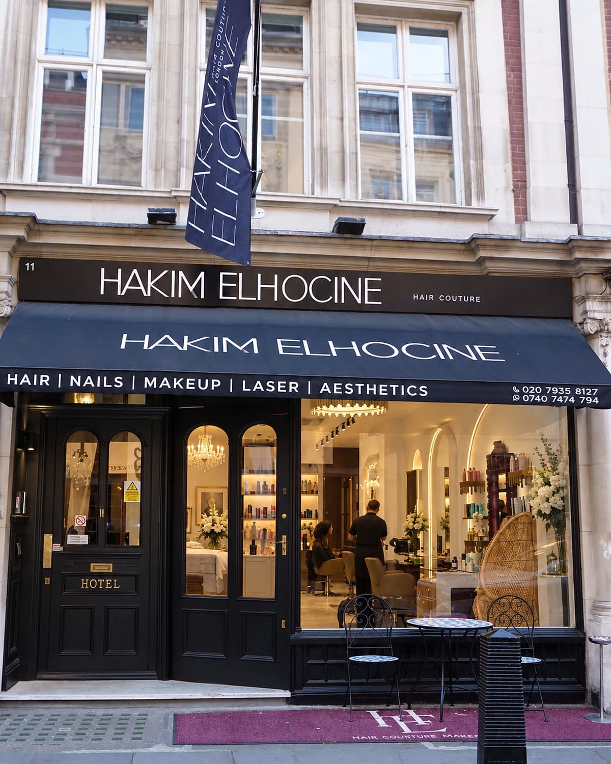 The shopfront of Hakim Elhocine Hair Couture at 11 Blenheim Street, Mayfair, under its navy awning